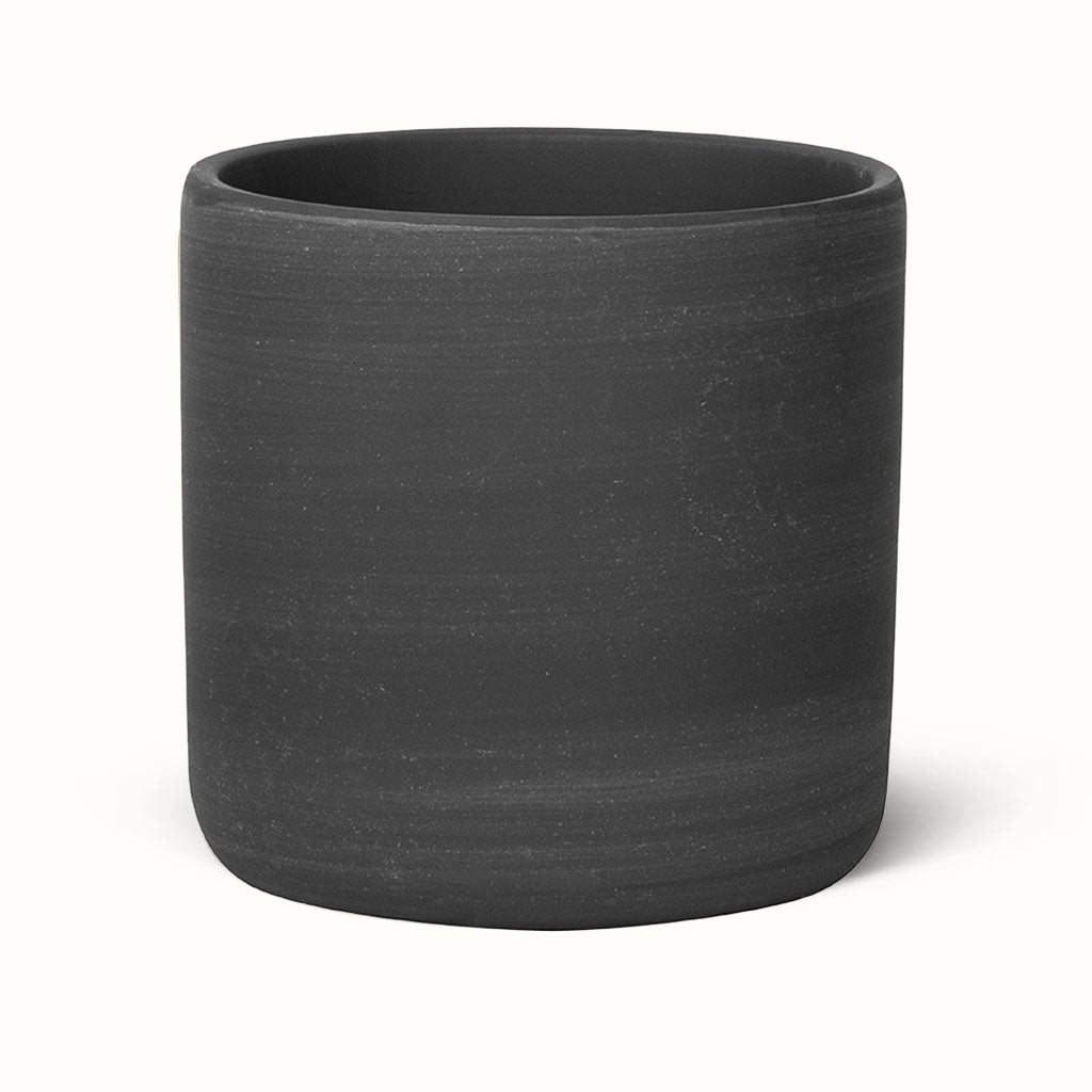 Sort Raw-potteskjuler med cylindrisk form, afrundet bund og fine, vandrette strukturer i overfladen.