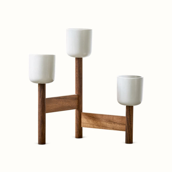 Et par UP-Wood Design vaser, der sidder på toppen af et træstativ.
