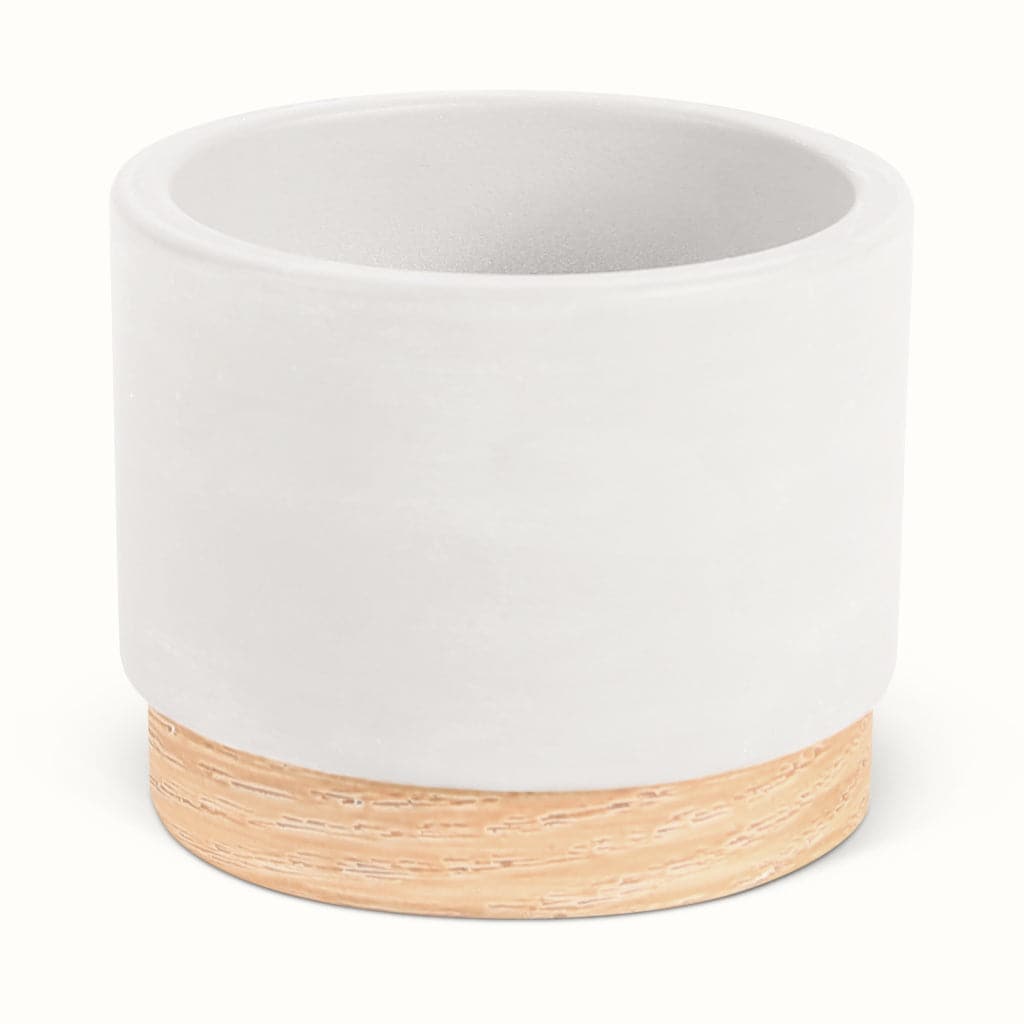 En hvid potteskjuler i keramik med træbund